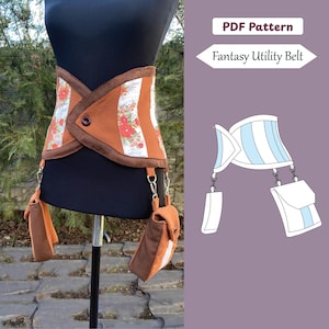 May include: A brown and floral patterned utility belt with two attached pouches. The belt features a button closure and is displayed on a mannequin. The image also includes a diagram labeled "PDF Pattern Fantasy Utility Belt."