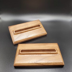 May include: Two wooden rectangular trays with a groove in the center. The trays are made of dark brown wood with a natural wood grain.