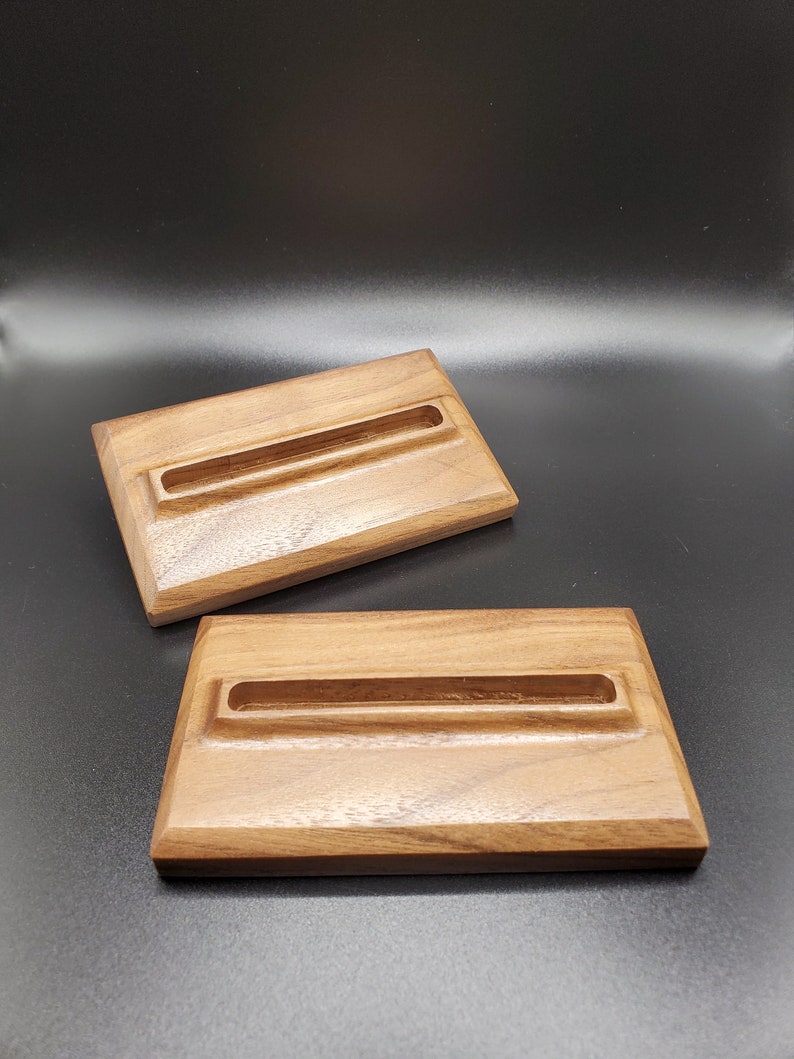 May include: Two wooden rectangular trays with a groove in the center. The trays are made of dark brown wood with a natural wood grain.