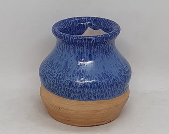 May include: A small blue ceramic planter with a speckled glaze and a brown base.