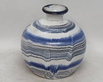 May include: A small, round, white ceramic vase with blue and grey stripes. The vase has a narrow opening at the top.