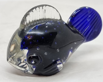 May include: A glass figurine of a blue and black fish with a clear fin. The fish has a textured, bubbly surface.