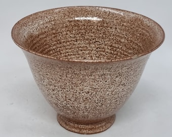 May include: A small, speckled brown ceramic bowl with a rounded bottom and a slightly flared rim.