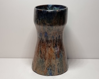 Könnte beinhalten: Eine Keramikvase mit brauner, blauer und grüner Glasur. Die Vase hat eine breite Öffnung und eine schmale Taille.