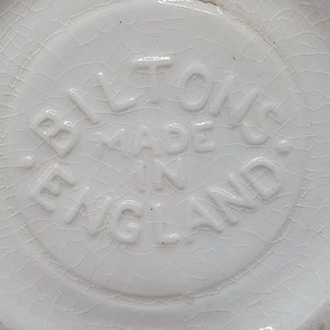 Puede incluir: Primer plano de una base de cer&aacute;mica blanca con el texto "Bilton's Made in England" en relieve.
