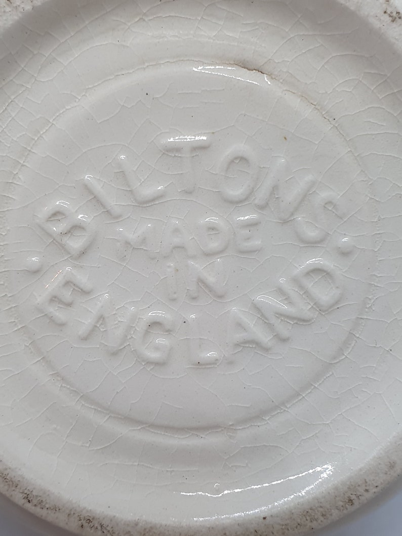 Puede incluir: Primer plano de una base de cer&aacute;mica blanca con el texto "Bilton's Made in England" en relieve.