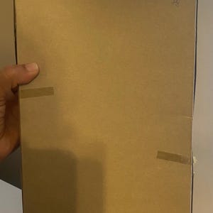 May include: A plain brown cardboard box with tape on the sides. The box is sealed and ready for shipping.
