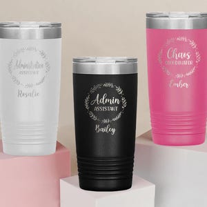 May include: Three stainless steel tumblers with different designs and names. The white tumbler says "Administrative Assistant Rosalie". The black tumbler says "Admin Assistant Bailey". The pink tumbler says "Chaos Coordinator Ember".