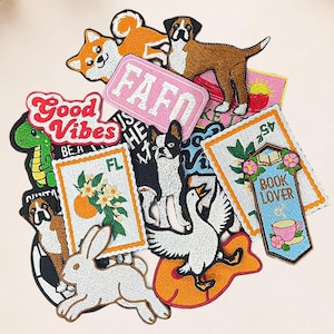 May include: A collection of embroidered patches featuring various designs including a white rabbit, a goose, a green dinosaur, a Boston Terrier, a brown dog, an orange fruit branch, a book lover sign with a teacup, and text reading FAFO and Good Vibes.
