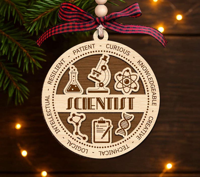 May include: A wooden Christmas ornament with the word "SCIENTIST" in the center. The ornament features science-related icons and words like "Patient" and "Curious" around the edge. It is decorated with a red and black plaid ribbon.