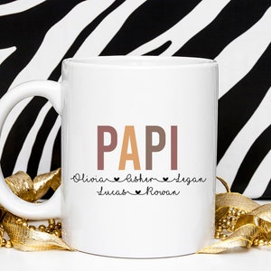 May include: White ceramic mug with a colorful "PAPI" design and the names "Olivia", "Esther", "Logan", "Lucas", and "Rowan" written below.