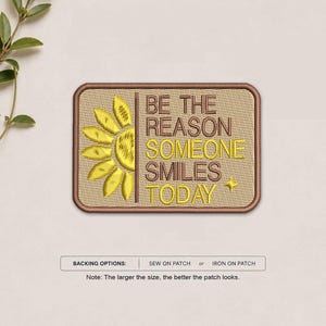 May include: A rectangular embroidered patch with a tan background and a brown border. It features a yellow sunflower graphic on the left and the text BE THE REASON SOMEONE SMILES TODAY in brown and yellow thread with a small yellow star.