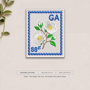 May include: A rectangular embroidered patch featuring a white background with a blue scalloped border. The design depicts a white Cherokee Rose flower with yellow centers, green leaves, and the blue text GA and 88 cents. Backing options include sew or iron.