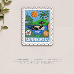 May include: A rectangular embroidered patch shaped like a postage stamp featuring a loon on a blue lake, green hills, pine trees, a palm tree, and an orange sun. The word MINNESOTA is stitched in white at the bottom with white and orange flowers.