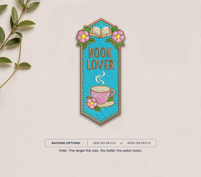 May include: A vertical embroidered patch with a bright blue background, featuring an open book, pink flowers, and a pink coffee cup with steam. The text BOOK LOVER is stitched in brown. Below, a label reads BACKING OPTIONS: SEW ON PATCH or IRON ON PATCH.
