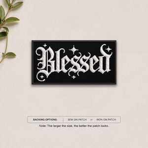 May include: A rectangular black embroidered patch featuring the word Blessed in white gothic-style lettering, accented with small white four-pointed stars. Below the patch, text indicates backing options of sew on or iron on patch.