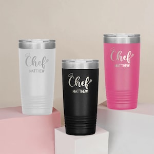 May include: Three stainless steel tumblers with a white, black, and pink finish. Each tumbler has a silver lid and is engraved with the text "Chef Matthew".