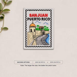 May include: A rectangular embroidered patch shaped like a postage stamp featuring a scene of San Juan, Puerto Rico. The design includes a tan stone fortress with a dome, green foliage, and blue water. The text SAN JUAN PUERTO RICO is stitched in red and black.