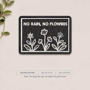 May include: A rectangular embroidered patch with a black background and a white border. The patch features the white text NO RAIN, NO FLOWERS above a line drawing of three stylized flowers with leaves. The backing options are sew-on or iron-on.