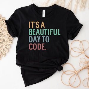 May include: Black t-shirt with the text "It's a beautiful day to code." in rainbow colors.