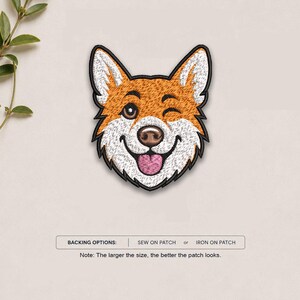 May include: An embroidered patch featuring the face of a Corgi dog with orange and white fur, a black nose, and a pink tongue, shown winking. Below the patch, text reads: BACKING OPTIONS: SEW ON PATCH or IRON ON PATCH. Note: The larger the size, the better the patch looks.