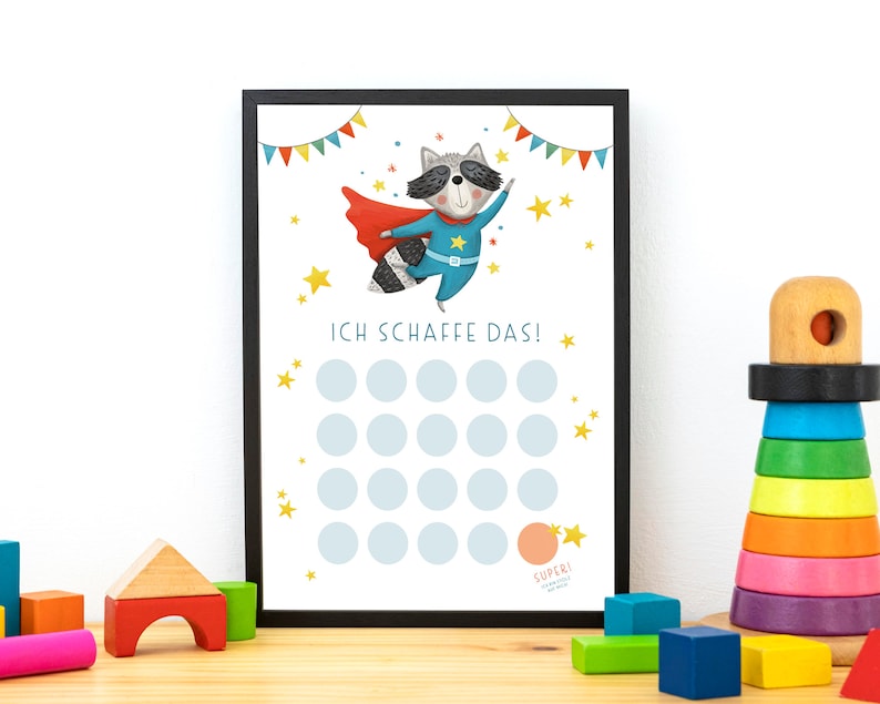 May include: A printable chart with a raccoon superhero character wearing a red cape and blue suit. The chart has 25 circles for marking progress and the text "ICH SCHAFFE DAS!" in German. The chart is framed in black.