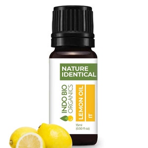 May include: A 15 ml (0.50 fl oz) bottle of Indo Bio Organics Lemon Oil, labelled "Nature Identical". The bottle is brown glass with a black cap. Two lemons and green leaves are in the foreground.