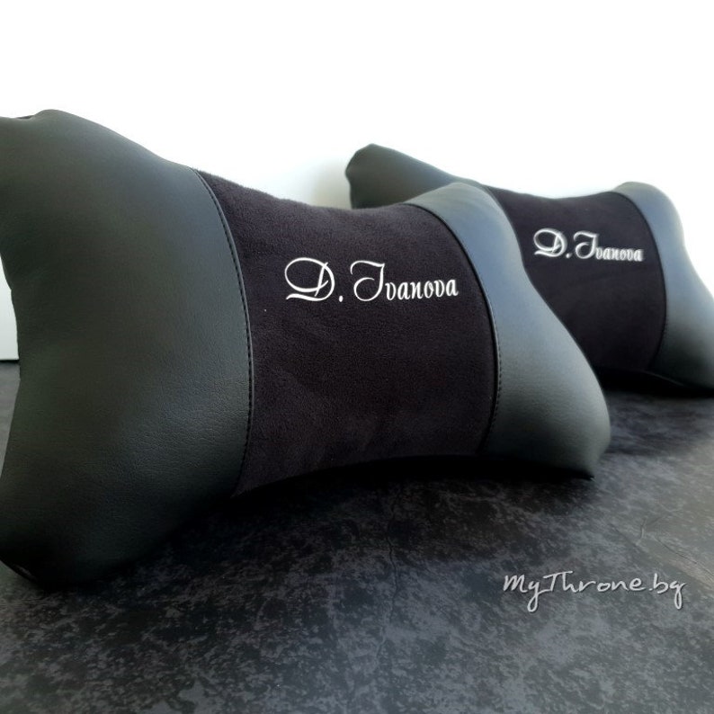 May include: Two black and gray car headrests with the name "D. Ivanova" embroidered in white on each.