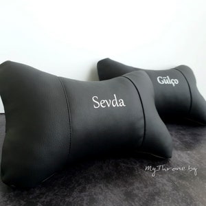 May include: Two black leather car headrests with white embroidered names "Sevda" and "G&uuml;l&ccedil;&ouml;".
