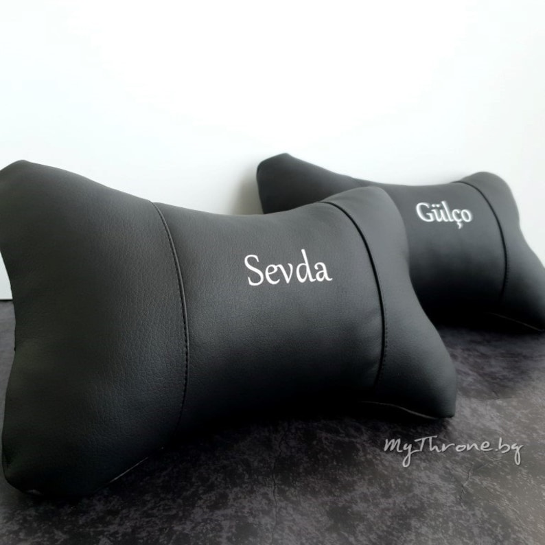 May include: Two black leather car headrests with white embroidered names "Sevda" and "G&uuml;l&ccedil;&ouml;".