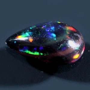 Peergeslepen zwarte Ethiopische opaal – natuurlijke vuuropaal cabochon, 6 x 9 mm