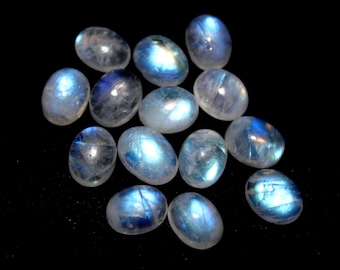 May include: A collection of oval-shaped moonstone cabochons with a milky white color and iridescent blue sheen.
