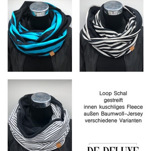 Könnte beinhalten: Zwei schwarz-weiß gestreifte Schlauchschals mit schwarzem Fleece-Futter. Die Schals werden auf Mannequins mit schwarzen Jacken präsentiert. Der Text "Loop Schal gestreift innen kuschliges Fleece außen Baumwoll-Jersey verschiedene Varianten DE-DELUXE decoration-garden-handmade goods" ist unter den Schals gedruckt.