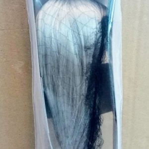 May include: A white wig with a black net, packaged in a clear plastic bag.