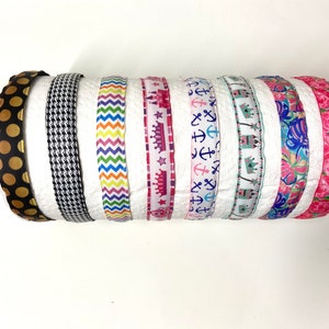 May include: Eight different patterned ribbons, including polka dots, houndstooth, rainbow stripes, crowns, anchors, and floral designs.