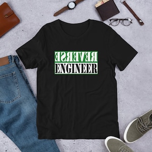 May include: Black t-shirt with white text that reads "REVERSE ENGINEER" in a green box.