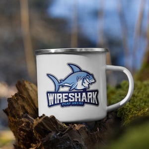 Może przedstawiać: Biały emaliowany kubek do campingu z grafiką niebieskiego rekina i tekstem "Wireshark PCAP Artist".