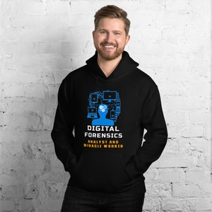 Könnte beinhalten: Schwarzer Kapuzenpullover mit einer blauen Silhouette einer Person mit Computer-Icons um den Kopf. Der Text "Digital Forensics Analyst and Miracle Worker" ist in Orange unter der Silhouette gedruckt.