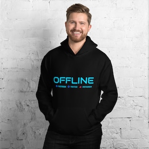 Puede incluir: Sudadera con capucha negra con un gráfico azul "OFFLINE" y iconos de redes sociales debajo. El texto dice "FACEBOOK, TWITTER, INSTAGRAM".