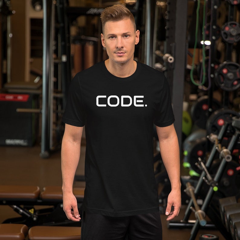 May include: A black t-shirt with the word "CODE." printed in white on the front. The shirt is being worn by a person in a gym setting.