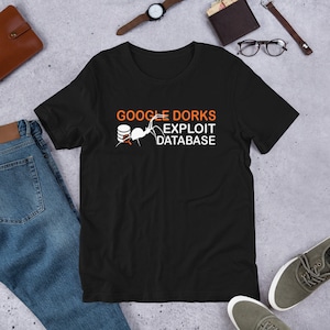 Könnte beinhalten: Schwarzes T-Shirt mit weißem Text, der "Google Dorks Exploit Database" lautet. Eine weiße Spinne kriecht auf einem Datenbanksymbol.