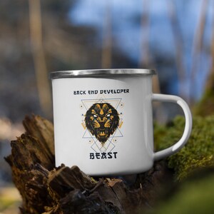 May include: White enamel camping mug with a black and gold geometric design featuring a lion's head and the text "Back End Developer Beast".