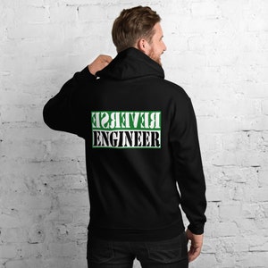 Könnte beinhalten: Schwarzer Kapuzenpullover mit einem grünen Rechteck auf der Rückseite, auf dem in weißen Buchstaben "REVERSE ENGINEER" steht.