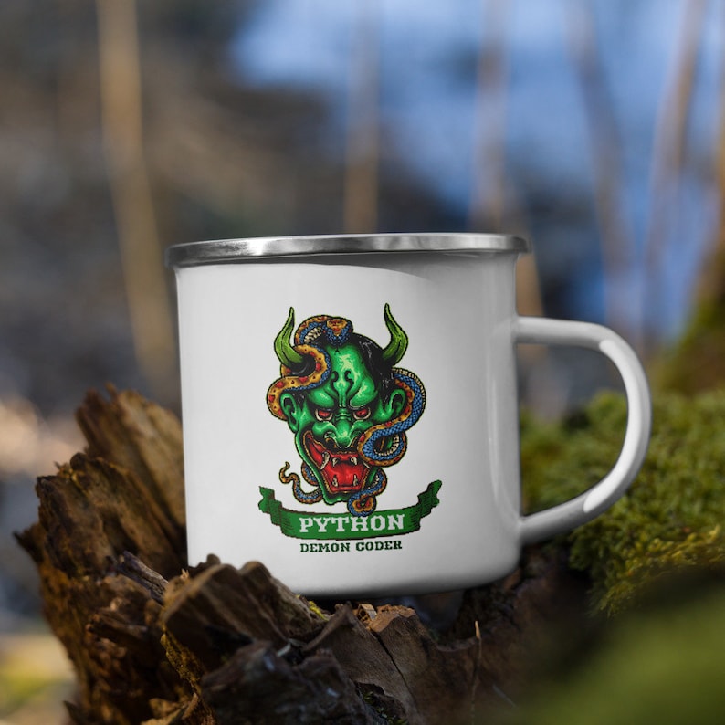 May include: White enamel mug with a green demon face with a snake wrapped around it. The mug has the text "Python Demon Coder" on it.