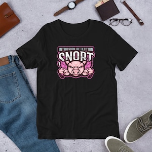 Könnte beinhalten: Schwarzes T-Shirt mit einem rosa Schweine-Grafik und dem Text "INTRUSION DETECTION SNORT". Das Schwein hält zwei rosa Spielzeugpistolen. Das T-Shirt besteht aus einem weichen Material.