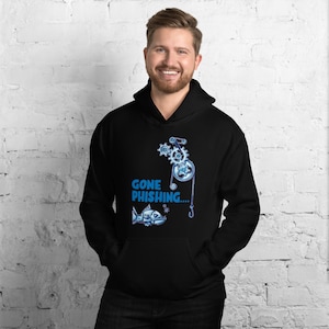 Könnte beinhalten: Ein schwarzer Hoodie mit einer blauen und weißen Grafik eines Fisches, der von einem mechanischen Gerät eingeholt wird. Der Text "GONE PHISHING..." ist auf dem Hoodie aufgedruckt.