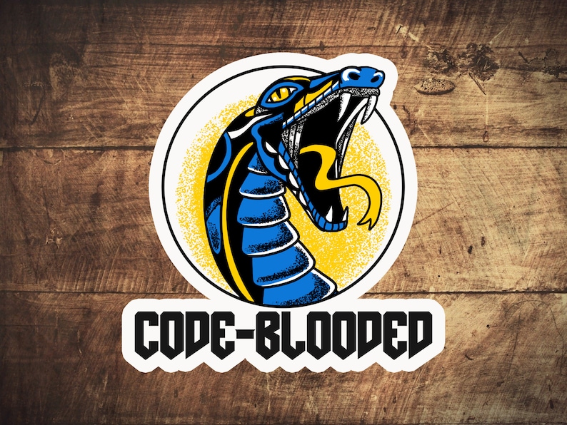 Pu&ograve; includere: Un adesivo bianco con una testa di serpente blu e nera su sfondo giallo. Il testo "CODE-BLOODED" &egrave; sotto la testa di serpente.