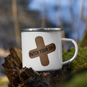 Könnte beinhalten: Weiße Emaille-Tasse mit einem braunen Pflaster-Motiv und dem Text "PATCH YOUR SH*T".