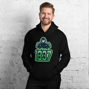May include: Black hooded sweatshirt with a green and white graphic of a skull in a hood, with the number "1337" in green. The sweatshirt has a front pocket and a drawstring hood.