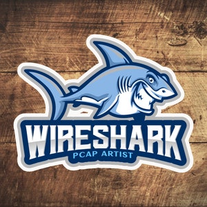 Op de afbeelding: Een blauw en wit logo met een cartoonhaai en de tekst "Wireshark PCAP Artist".